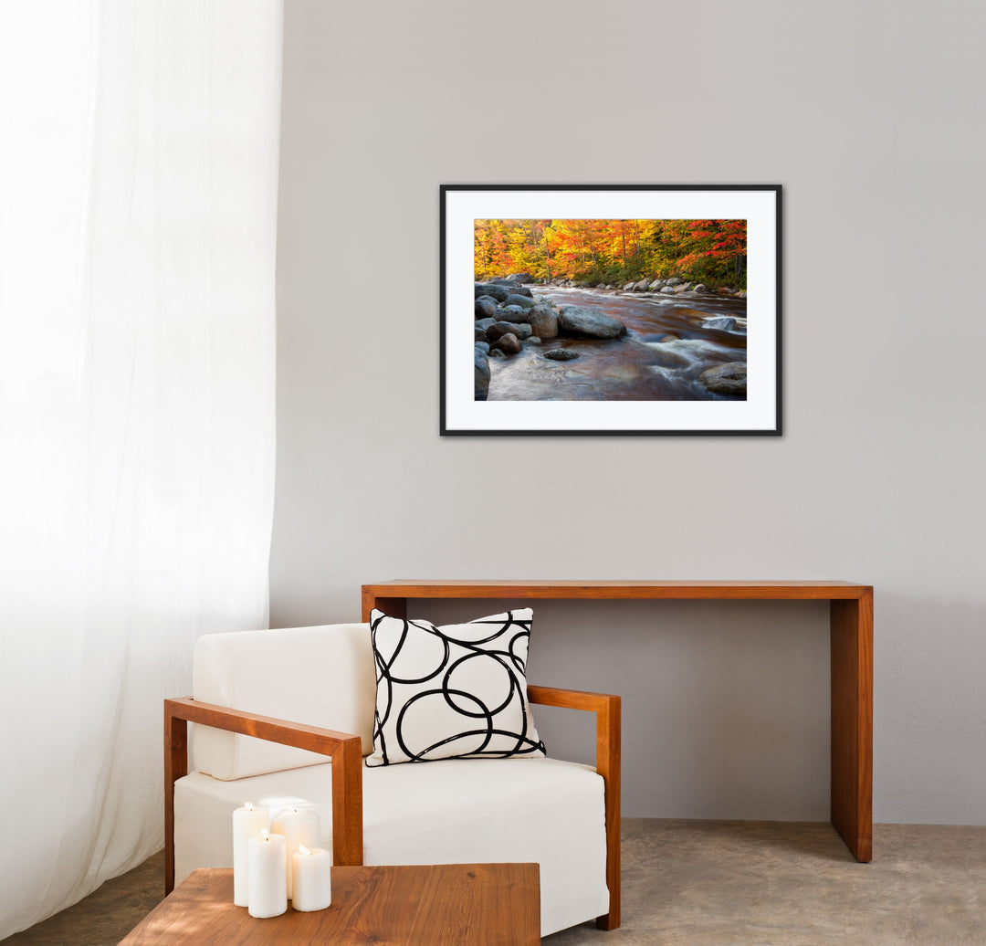 Framed photograph of a river with autumn trees in a living room setting.