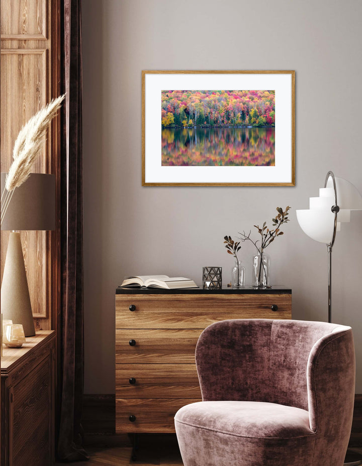Decorative room interior with a framed artwork, wooden dresser, and purple chair.